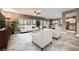 Staged open-plan living area with modern furniture, tile flooring, and seamless flow into the kitchen at 2810 Somerset Springs Dr, Henderson, NV 89052