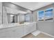 Bathroom featuring double sinks, white cabinets, a large mirror, and tile floors at 3192 Timorasso Ave, Henderson, NV 89044