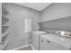 Laundry room with white washer, dryer, and open shelving at 3192 Timorasso Ave, Henderson, NV 89044