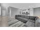 Open-concept living room, kitchen with stainless appliances, and L-shaped sofa at 3192 Timorasso Ave, Henderson, NV 89044