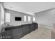 Spacious living room featuring a comfortable gray sectional and tiled flooring at 3192 Timorasso Ave, Henderson, NV 89044