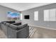 Bright living room with a modern gray sectional sofa and large windows at 3192 Timorasso Ave, Henderson, NV 89044