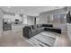 Open-concept living room, kitchen with stainless appliances, and L-shaped sofa at 3192 Timorasso Ave, Henderson, NV 89044