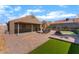 Private backyard featuring a covered patio, built-in grill and artificial turf, perfect for relaxation and entertaining at 3443 Citruscedar Way, North Las Vegas, NV 89032
