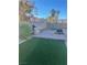 View of backyard featuring a built-in grill, firepit, artificial grass, and rock landscaping at 3443 Citruscedar Way, North Las Vegas, NV 89032