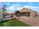 Private backyard with mature landscaping, a brick paver patio, covered area, and a built-in grill at 3443 Citruscedar Way, North Las Vegas, NV 89032