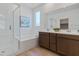 Modern bathroom with a soaking tub, glass-enclosed shower, and double vanity sinks at 3709 Neblina Dr, Henderson, NV 89052