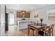 Modern kitchen featuring wood cabinets, stainless steel appliances, a white countertop island, and a dining area at 3709 Neblina Dr, Henderson, NV 89052