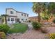 Lush backyard with green grass, desert landscaping, mature trees, and a seating area at 4114 Jessica Marie St, North Las Vegas, NV 89032