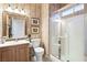 Classic bathroom with floral wallpaper, framed artwork, a vanity with a sink, and a glass-enclosed shower at 4114 Jessica Marie St, North Las Vegas, NV 89032