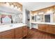 Bathroom with double sinks, wood cabinets, decorative wallpaper, and a separate shower and tub at 4114 Jessica Marie St, North Las Vegas, NV 89032