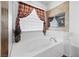Bright bathroom features a tiled tub with a decorative plant and a large window for natural light at 4114 Jessica Marie St, North Las Vegas, NV 89032