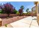Landscaped backyard with patio, block wall, rockscape, mature trees, and tropical plants at 432 Emerald Heights St, Las Vegas, NV 89144