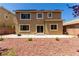 Tan two-story home with backyard featuring rock landscaping, patio, and trees at 432 Emerald Heights St, Las Vegas, NV 89144