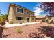 Two-story home with large windows, a patio, rock landscaping, and mature tree at 432 Emerald Heights St, Las Vegas, NV 89144