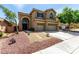 Two-story home with a three car garage, covered porch and desert landscaping at 432 Emerald Heights St, Las Vegas, NV 89144