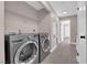 Bright laundry room featuring modern gray washer and dryer, and convenient overhead shelving at 4324 W Lake Mead Blvd # 202, Las Vegas, NV 89108
