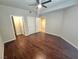 An inviting bedroom features wood flooring, a ceiling fan, and doorways to the closet and bathroom at 4675 Basilicata Ln # 103, North Las Vegas, NV 89084