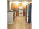 Well-lit kitchen with stainless steel appliances, wooden cabinets and tile floor at 4675 Basilicata Ln # 103, North Las Vegas, NV 89084