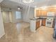 Living room and kitchen area featuring tile floors and modern appliances at 4675 Basilicata Ln # 103, North Las Vegas, NV 89084