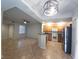 Open living room and kitchen area with tile floors and modern lighting fixtures at 4675 Basilicata Ln # 103, North Las Vegas, NV 89084