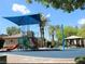 Community playground with blue canopy, slides, and green climbing structure at 4675 Basilicata Ln # 103, North Las Vegas, NV 89084