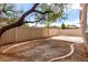 A backyard space featuring a concrete patio, shaded by mature trees at 4705 Delicate Arch Ct, North Las Vegas, NV 89031