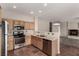 Kitchen has stainless appliances, wood cabinets, light countertops, and a view into the living room at 4705 Delicate Arch Ct, North Las Vegas, NV 89031