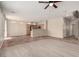 Open-concept living space with wood-look flooring, a kitchen view, and abundant natural light at 4705 Delicate Arch Ct, North Las Vegas, NV 89031