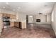 Open-concept living space features a kitchen, living room, and seamless tile to wood flooring at 4705 Delicate Arch Ct, North Las Vegas, NV 89031