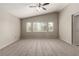 Spacious primary bedroom with carpet, ceiling fan, and windows at 4705 Delicate Arch Ct, North Las Vegas, NV 89031