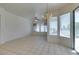 Bright dining room featuring an open floor plan with large windows, white walls, and ceramic tile flooring at 494 Dart Brook Pl, Henderson, NV 89012