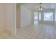 Bright living room featuring an open floor plan with large windows, white walls, and ceramic tile flooring at 494 Dart Brook Pl, Henderson, NV 89012