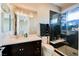 Modern bathroom with dark wood vanity, glass shower, and sleek fixtures at 5 Crystal Tree Pass, Henderson, NV 89052