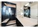 Modern bathroom with black tiled shower, white countertops, and large mirror at 5 Crystal Tree Pass, Henderson, NV 89052