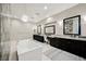Elegant main bathroom with double vanities, standalone tub, decorative chandelier, and tile accents at 5 Crystal Tree Pass, Henderson, NV 89052