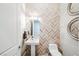 Chic powder room featuring herringbone accent wall, floating sink, and contemporary mirrors at 5 Crystal Tree Pass, Henderson, NV 89052
