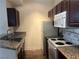 Well-lit kitchen with dark cabinetry, granite countertops, and modern white appliances at 5170 S Jones Blvd # 108, Las Vegas, NV 89118