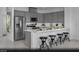 Modern kitchen with stainless steel appliances, gray cabinetry, a breakfast bar, and sleek countertops at 5761 Crenellated St # Lot 60, Las Vegas, NV 89148