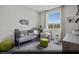 Charming secondary bedroom with a crib, comfortable chair, soft lighting, and a view of the landscape at 5761 Crenellated St # Lot 60, Las Vegas, NV 89148