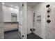 Spa-like bathroom boasts marble tile, a modern shower, and sleek black fixtures at 577 Overlook Rim Dr, Henderson, NV 89012