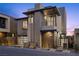 Modern two-story home featuring sleek design, wood accents, a balcony, and manicured landscaping at 577 Overlook Rim Dr, Henderson, NV 89012