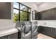 Modern laundry room featuring a washer and dryer, counter space, and storage cabinets at 584 Saint Croix St, Henderson, NV 89012