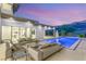 Evening shot of the backyard with a shimmering pool and an inviting lounge area, great for relaxation at 584 Saint Croix St, Henderson, NV 89012