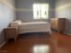 Bedroom featuring wood-look floors, a window and a full sized bed at 6086 Sunken River Trl, Las Vegas, NV 89118