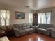Inviting living room with hardwood floors, comfortable sofas, and natural light at 6086 Sunken River Trl, Las Vegas, NV 89118