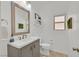 Neat bathroom with a gray vanity, neutral walls, framed mirror, and tiled floor at 6717 Lincoln Wood St, Las Vegas, NV 89149