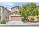 Charming two-story home with a tan exterior, well-maintained landscaping, and a spacious two-car garage at 6717 Lincoln Wood St, Las Vegas, NV 89149
