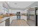 Bright kitchen with white cabinets, granite countertops, stainless steel appliances, and tile floors at 6717 Lincoln Wood St, Las Vegas, NV 89149