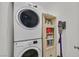 Efficient laundry area featuring a stacked washer and dryer, and storage cabinet for supplies at 6717 Lincoln Wood St, Las Vegas, NV 89149